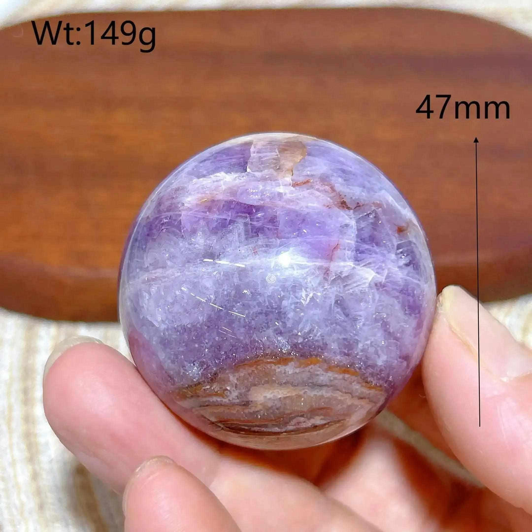 Hand-polished 47mm Amethyst Agate sphere featuring purple hues and banded white, gray, and brown patterns for meditation.