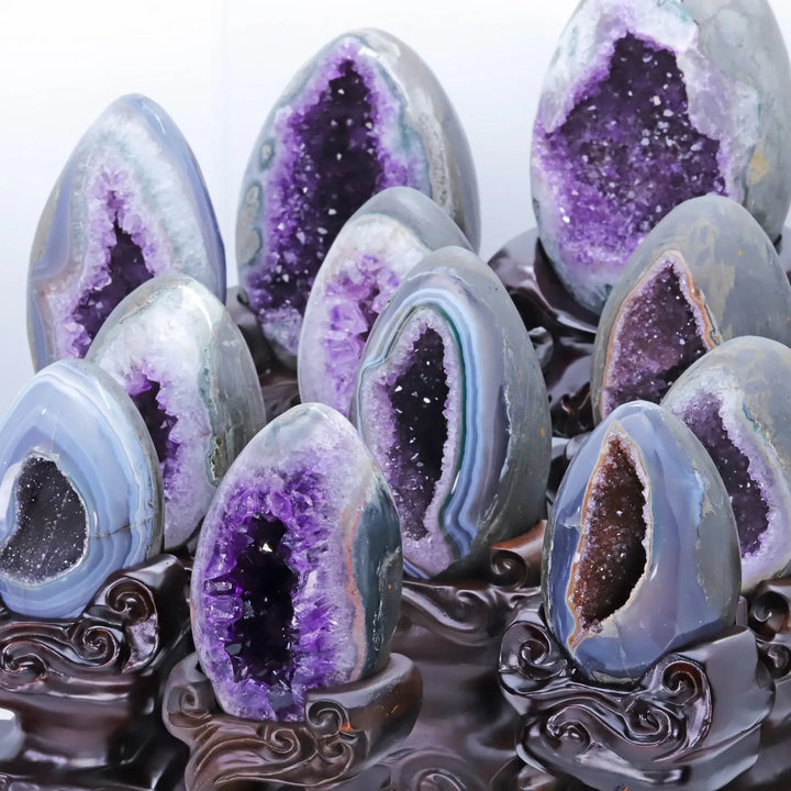 Stunning natural amethyst geode clusters on stands, showcasing deep violet crystals for peace and protection.