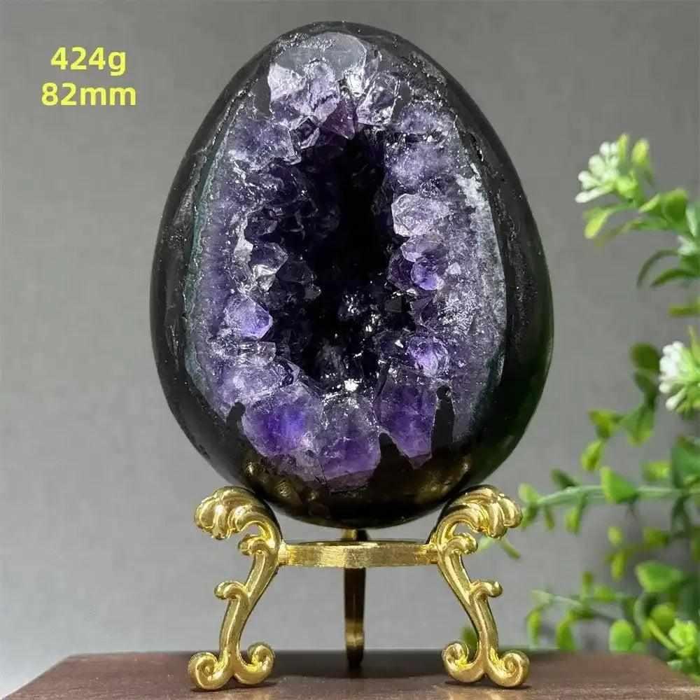 Amethyst geode dinosaur egg with sparkling purple crystals for calming energy, 82mm size, displayed on a gold stand.