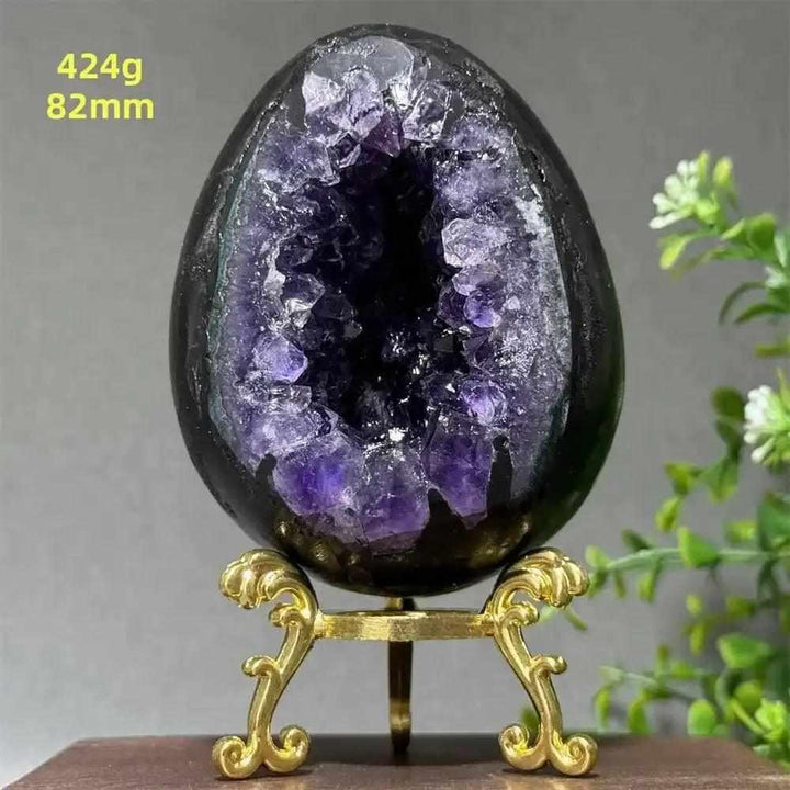 Amethyst geode dinosaur egg with sparkling purple crystals for calming energy, 82mm size, displayed on a gold stand.