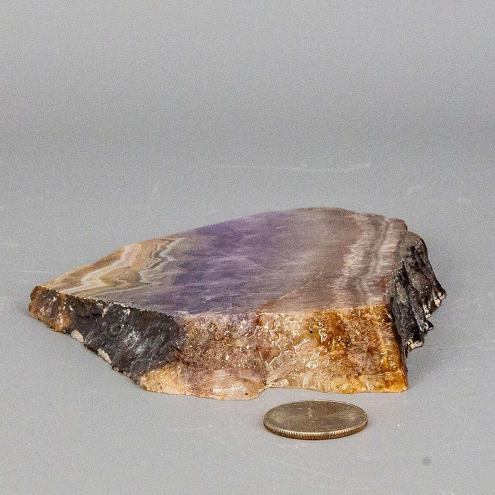 Amethyst "Laced" Agate Crystal Slab from Crystal Destiny, showcasing purple and brown hues with a quarter for scale.