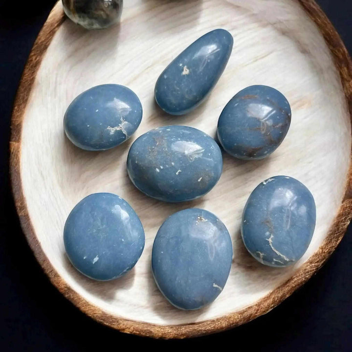 Polished blue Angelite palm stones with natural textures, perfect for calming meditation, reiki, and elegant home decor.