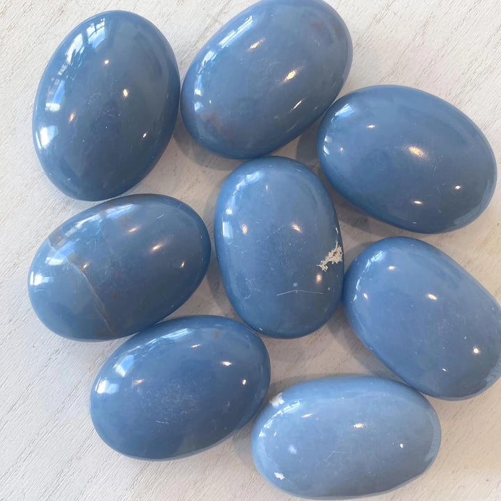 Polished Angelite Crystal Palm Stones in soft powder blue, perfect for anxiety relief and meditation.