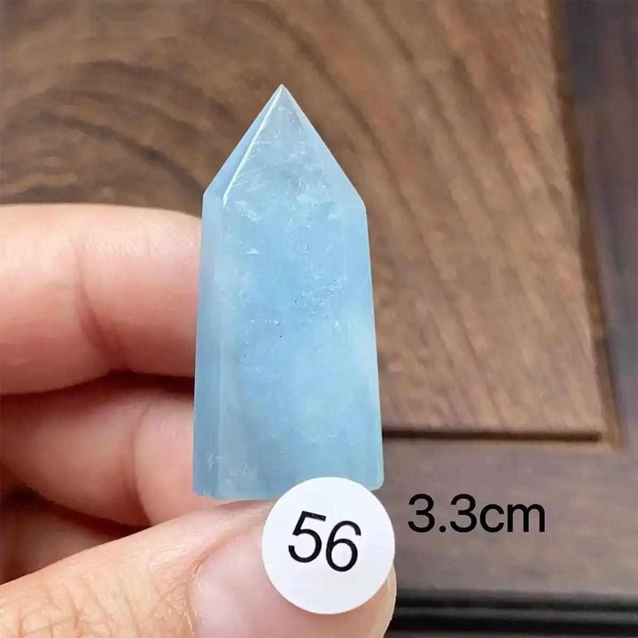 Hand-polished aquamarine mini tower with a faceted point, featuring a calming sea-blue color for throat chakra healing.