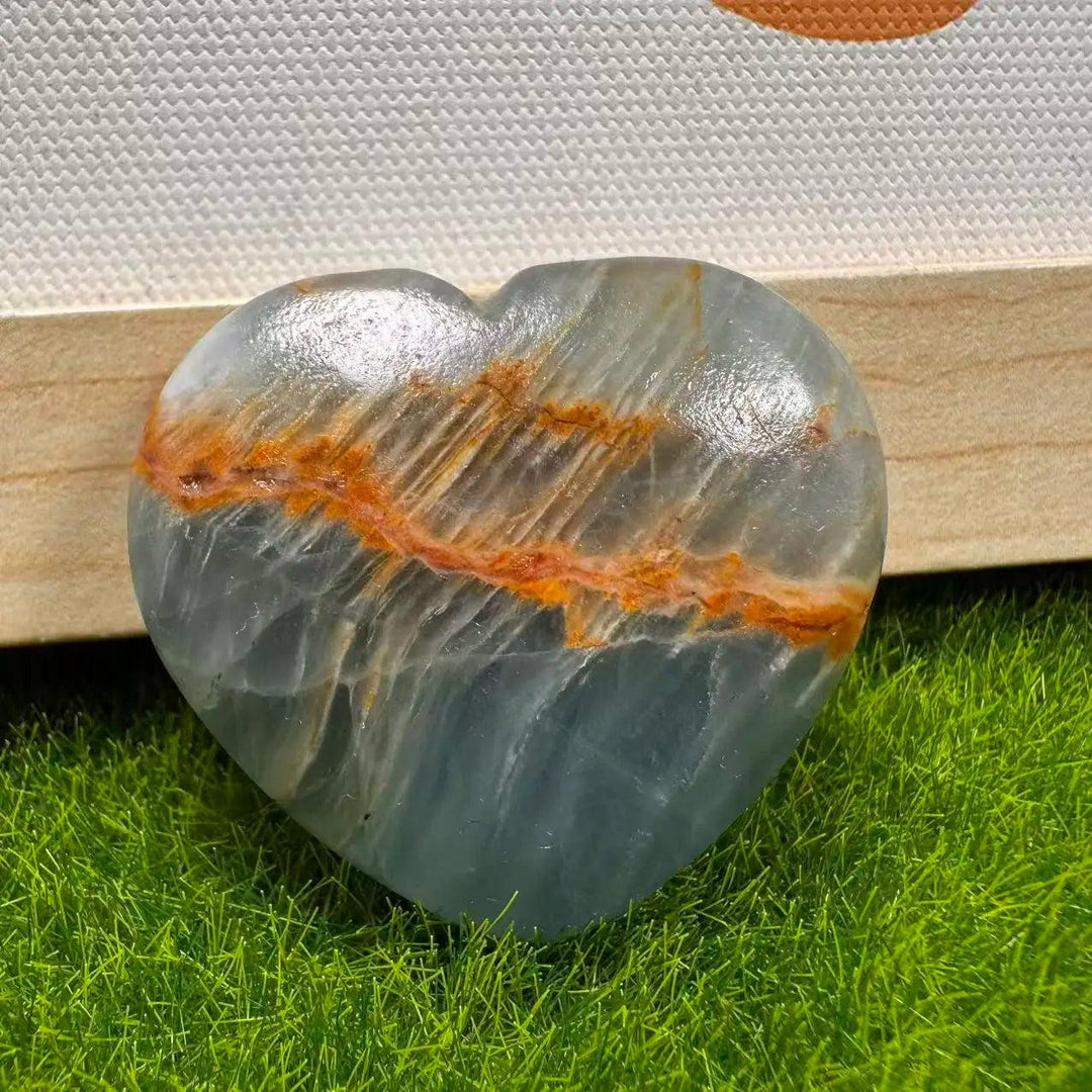 Polished Aquatine Lemurian Blue Calcite crystal heart with orange banding for anxiety relief.