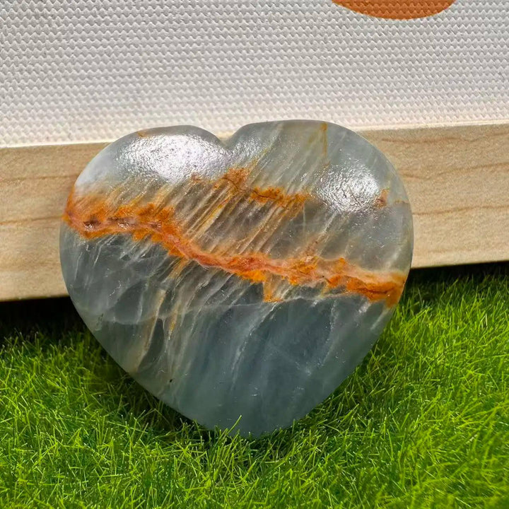 Polished Aquatine Lemurian Blue Calcite crystal heart with orange banding for anxiety relief.