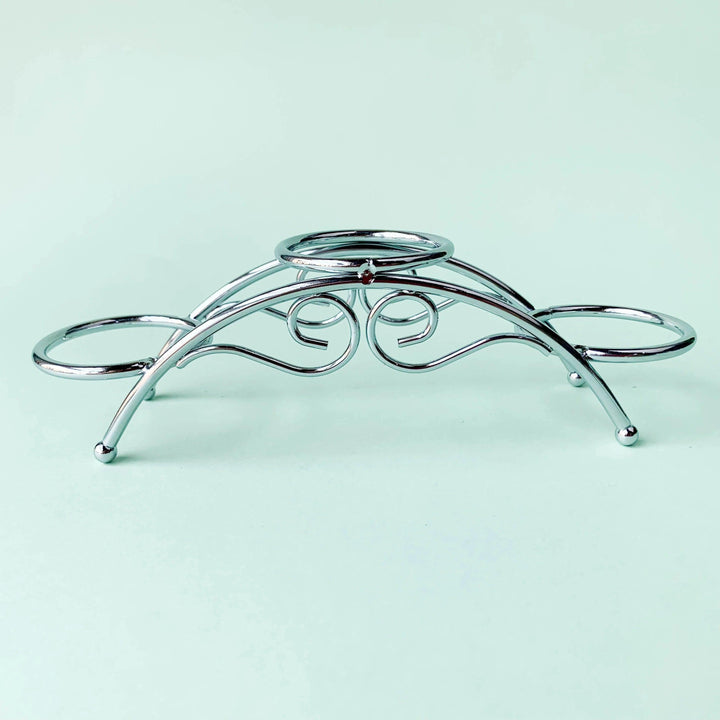Silvery arch crystal display stand with three sphere holders and elegant scrollwork.