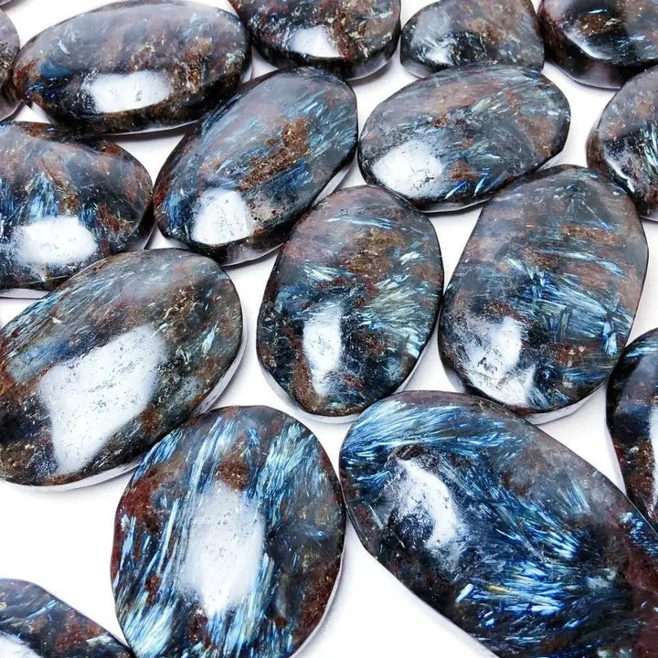 Polished Astrophyllite palm stone with shimmering blue starburst patterns, perfect for healing, meditation, and energy work.