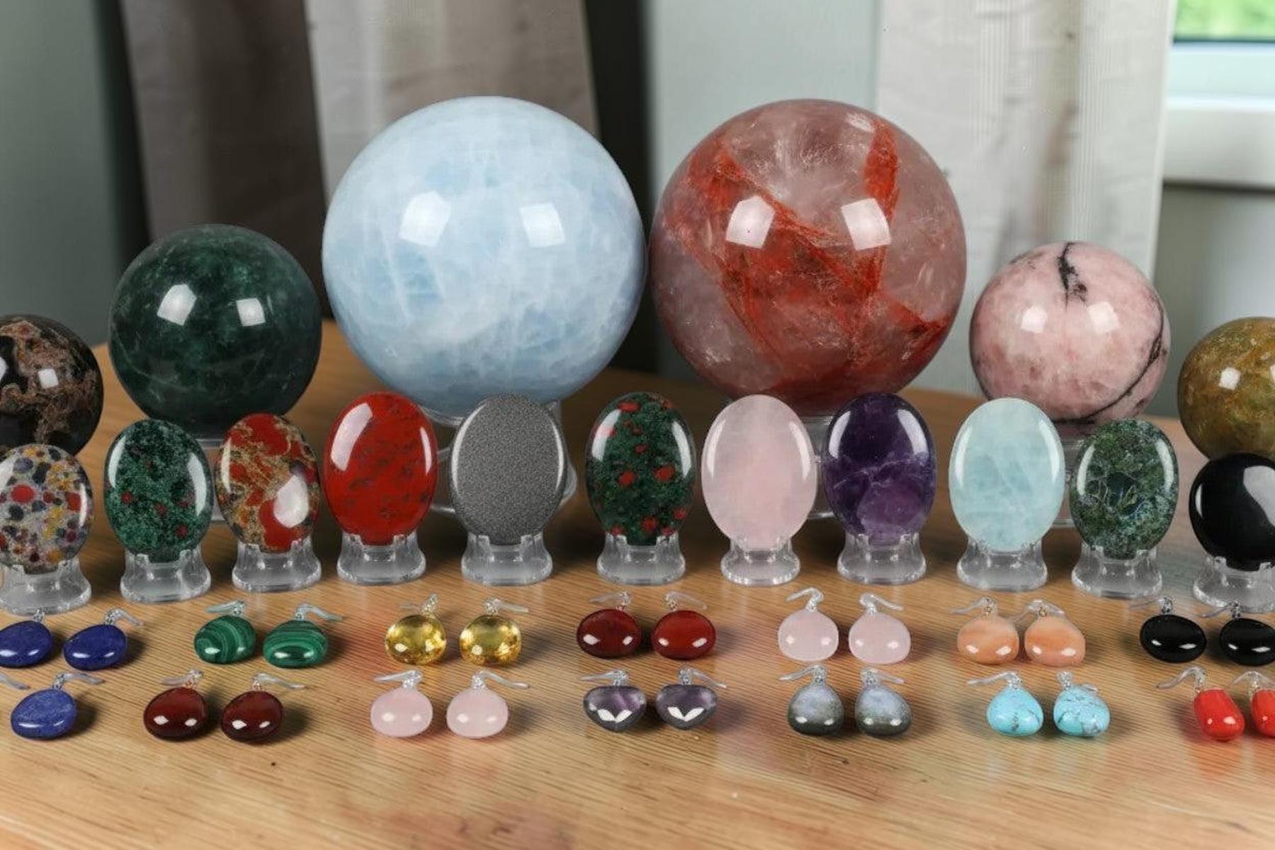 August Hero collection featuring polished crystal spheres, smooth gemstone eggs, and elegant teardrop earrings.