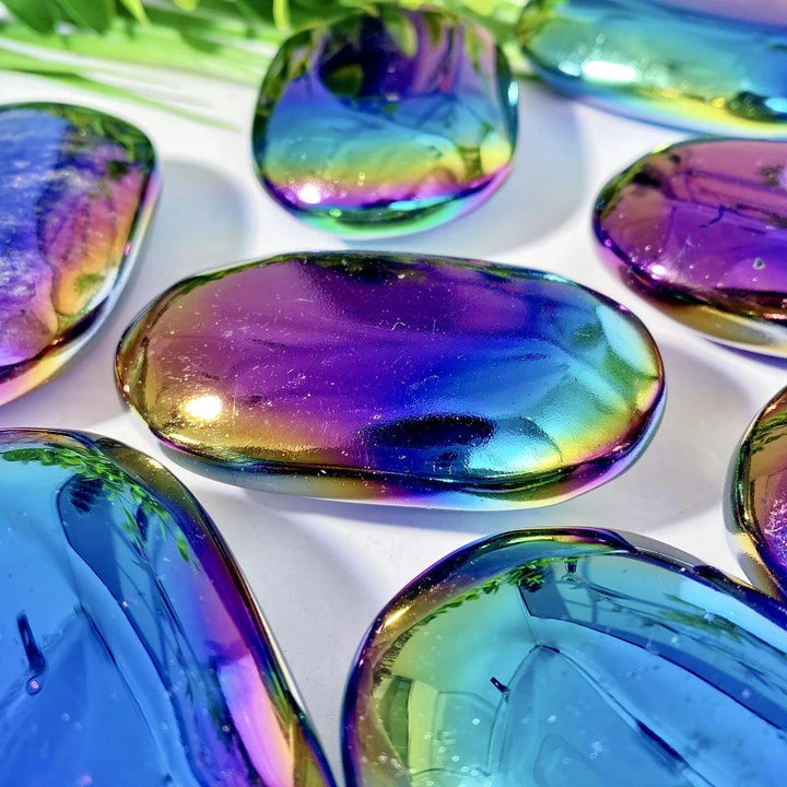Polished Aura Obsidian palm stone with iridescent blue and violet shimmer for grounding, protection, and transformation.