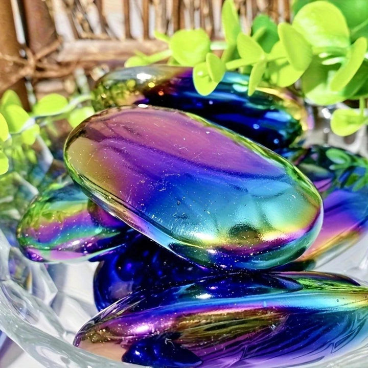 Polished Aura Obsidian palm stone with iridescent blue and purple shimmer for grounding and root chakra healing.