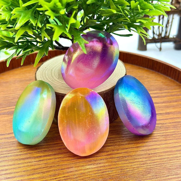 Four iridescent Aura Selenite Crystal Palm Stones with a rainbow shimmer for healing and cleansing.
