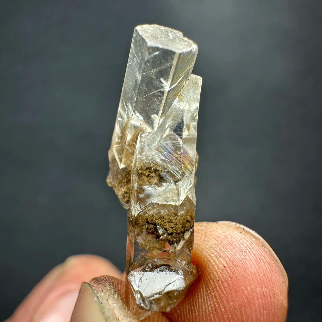 Natural clear aurora columnar calcite cluster crystal with healing rainbow inclusions.