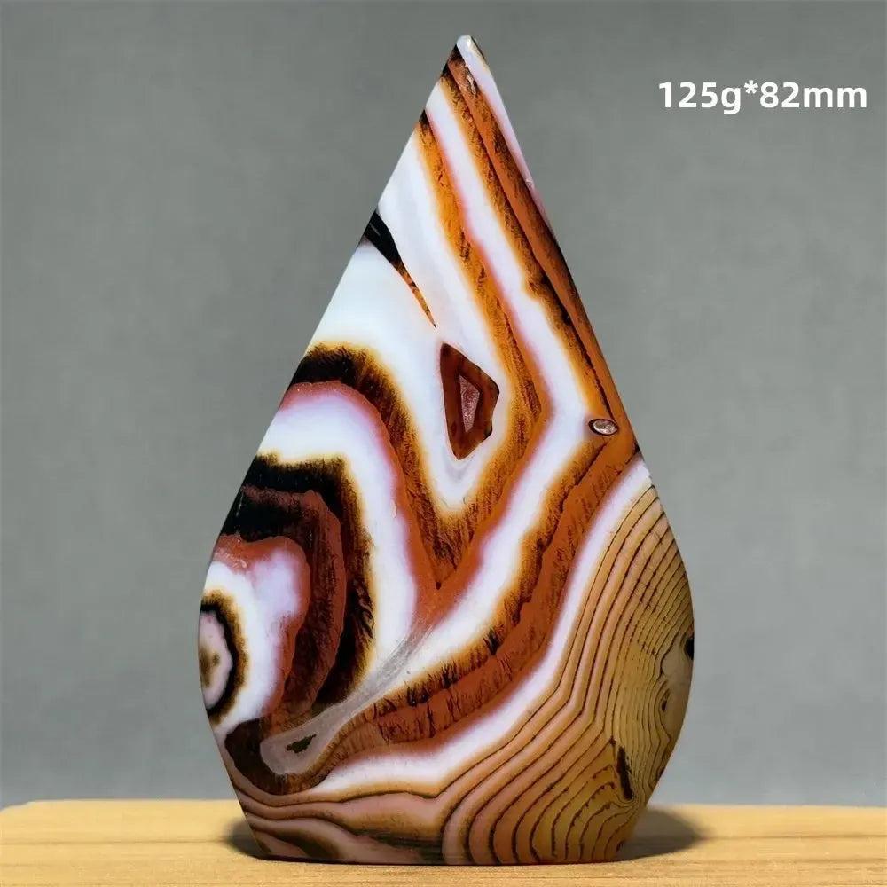 Banded Agate freeform torch from Crystal Destiny, featuring warm creams, browns, and white concentric stripes.