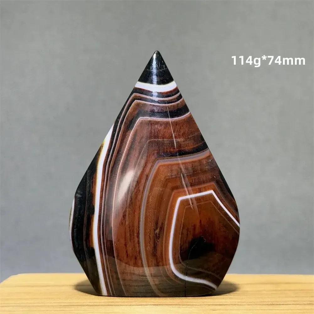 Banded Agate freeform torch from Crystal Destiny, featuring earthy brown, black, and white concentric stripes.