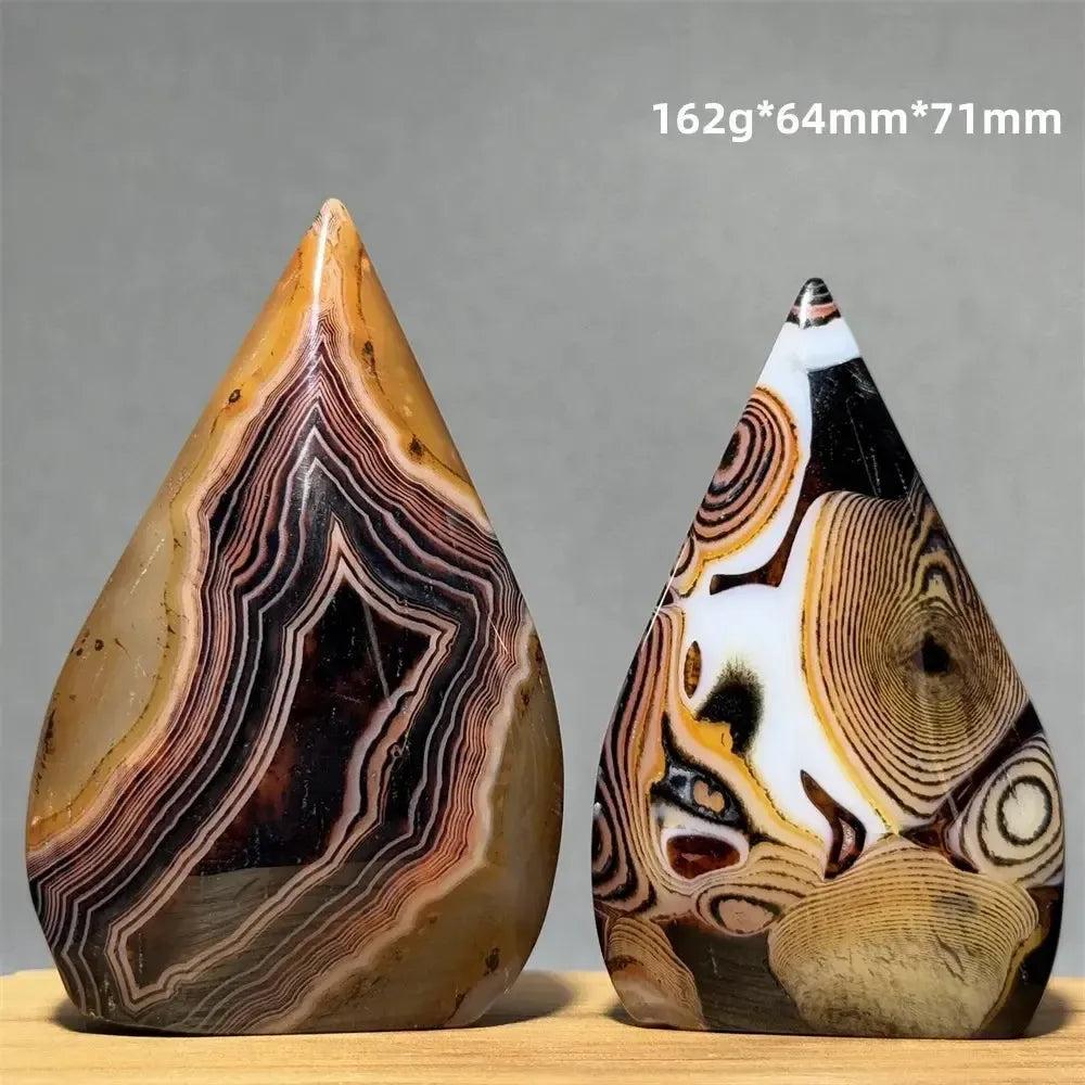 Two unique Banded Agate freeform torch specimens from Crystal Destiny, showcasing earthy tones and intricate patterns.