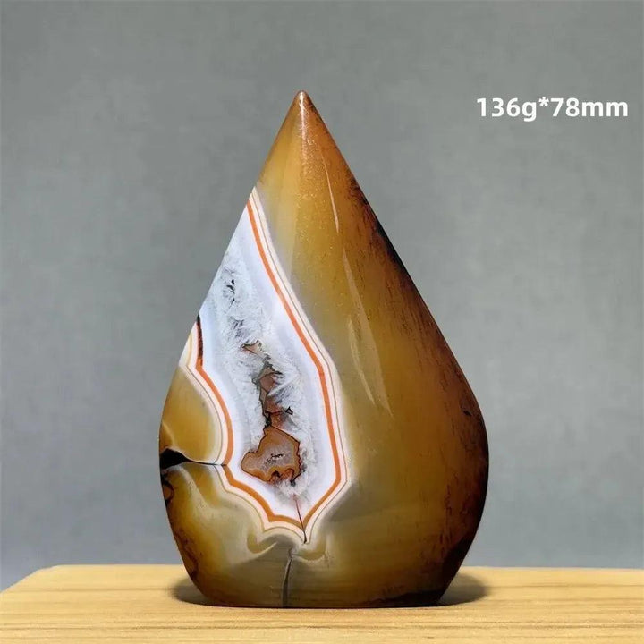 Crystal Destiny's banded agate freeform torch, a grounding natural mineral specimen with warm brown, white, and orange layers.