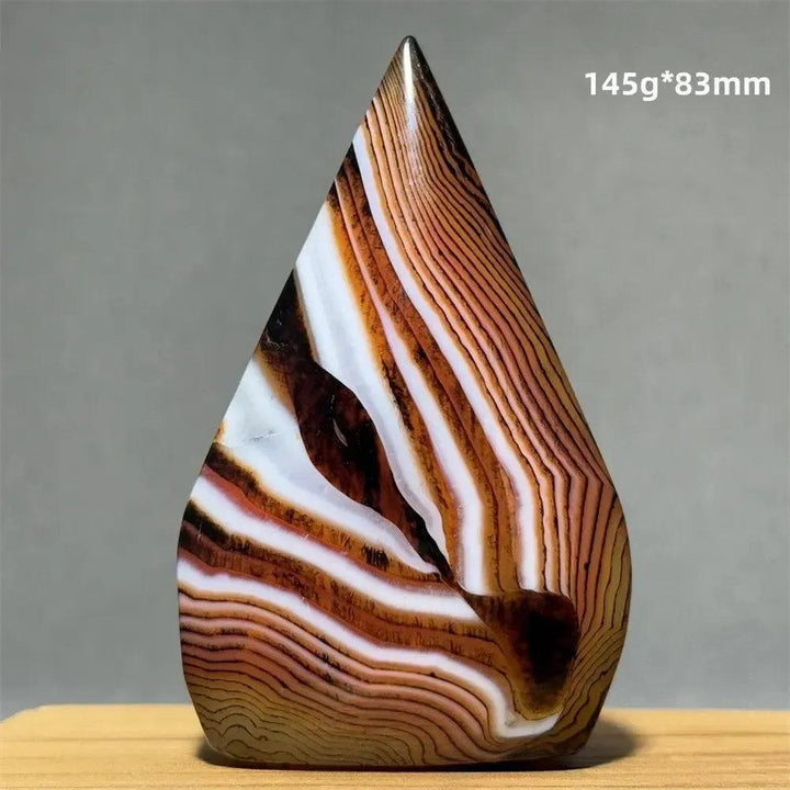 Banded Agate freeform torch from Crystal Destiny, featuring warm brown, white, and black concentric layers.