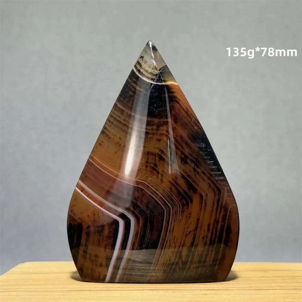 Banded Agate freeform torch from Crystal Destiny, featuring earthy brown, black, and white concentric stripes.