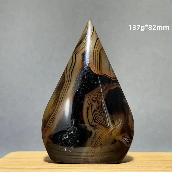 Banded Agate freeform torch from Crystal Destiny, featuring earthy brown, black, and cream concentric stripes.