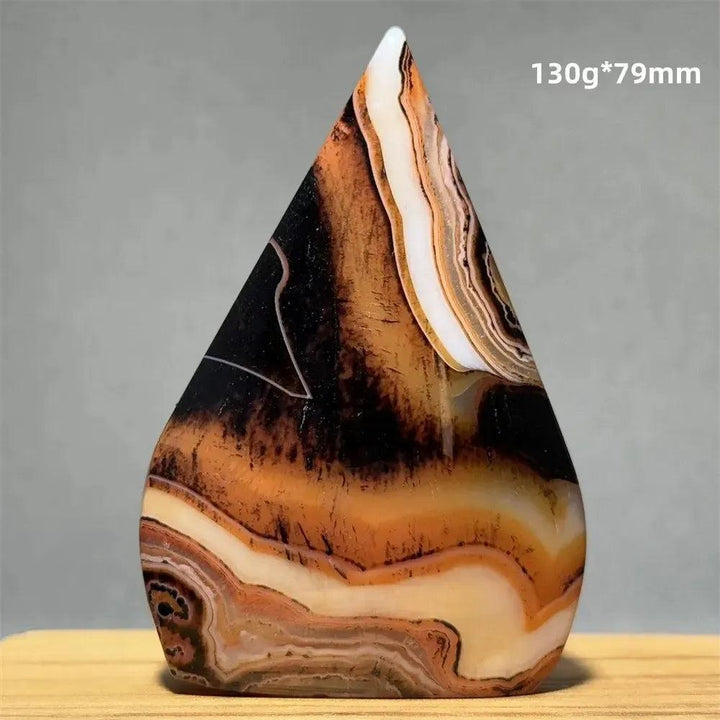 Banded Agate freeform torch from Crystal Destiny, featuring earthy browns, creams, and black concentric stripes.