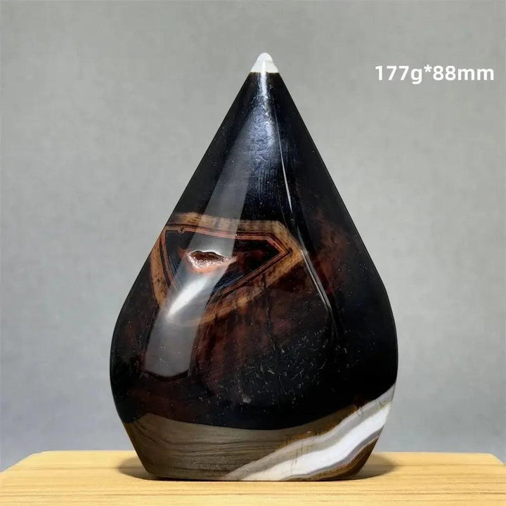 Banded Agate freeform torch from Crystal Destiny, featuring dark brown, black, and white layers with a small geode.