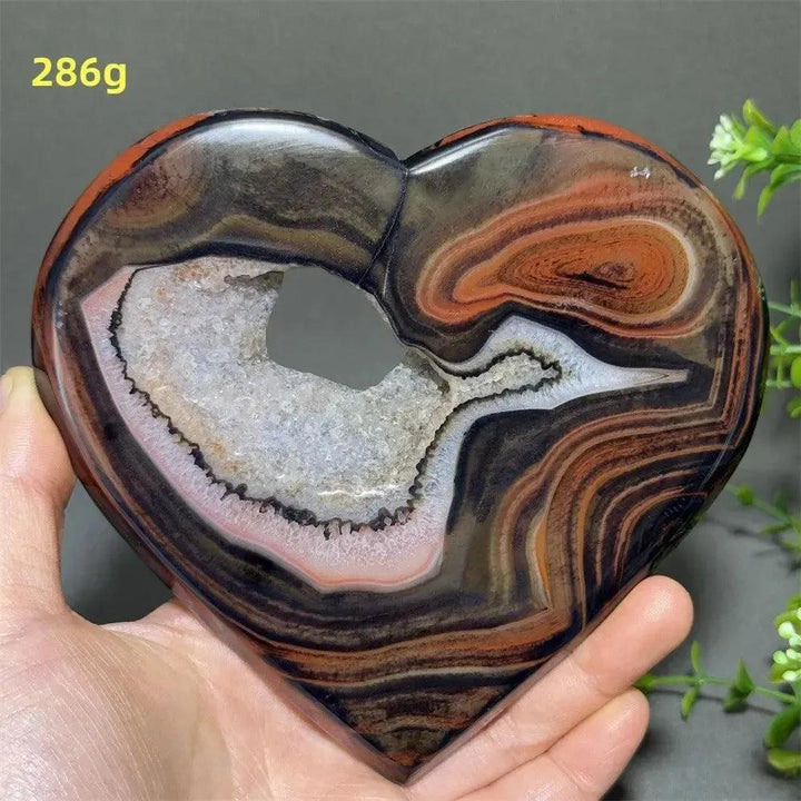 Banded Agate Geode Crystal Heart for grounding, stability, and emotional balance. Polished red, black, brown, white banding with a glittering druzy cavity.
