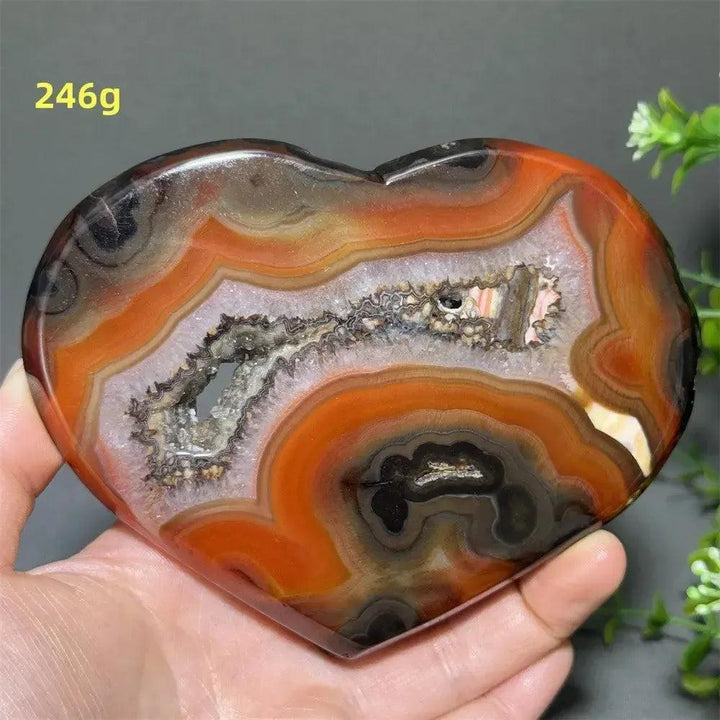 Banded Agate Geode Crystal Heart for Grounding & Stability, with red, black, brown, and white concentric layers.