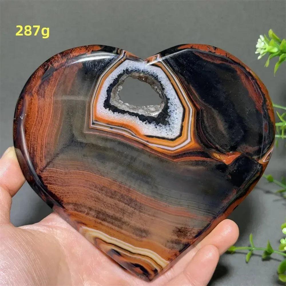 Banded Agate Geode Crystal Heart for Grounding & Stability, with red, black, brown, and white concentric layers.
