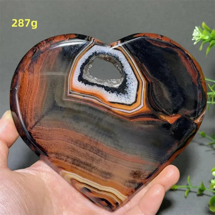 Banded Agate Geode Crystal Heart for Grounding & Stability, with red, black, brown, and white concentric layers.