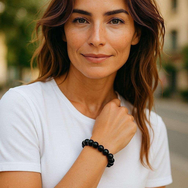 Woman wearing a Black Agate Crystal Beaded Bracelet, 10mm polished deep black beads for grounding and protection.