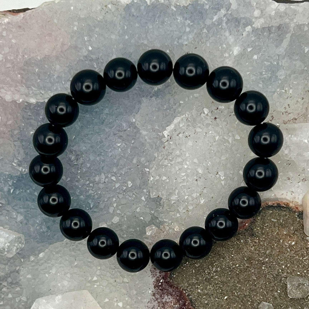 Black Agate Beaded Bracelet: sleek, polished black beads on an elastic cord, offering powerful protective energy.
