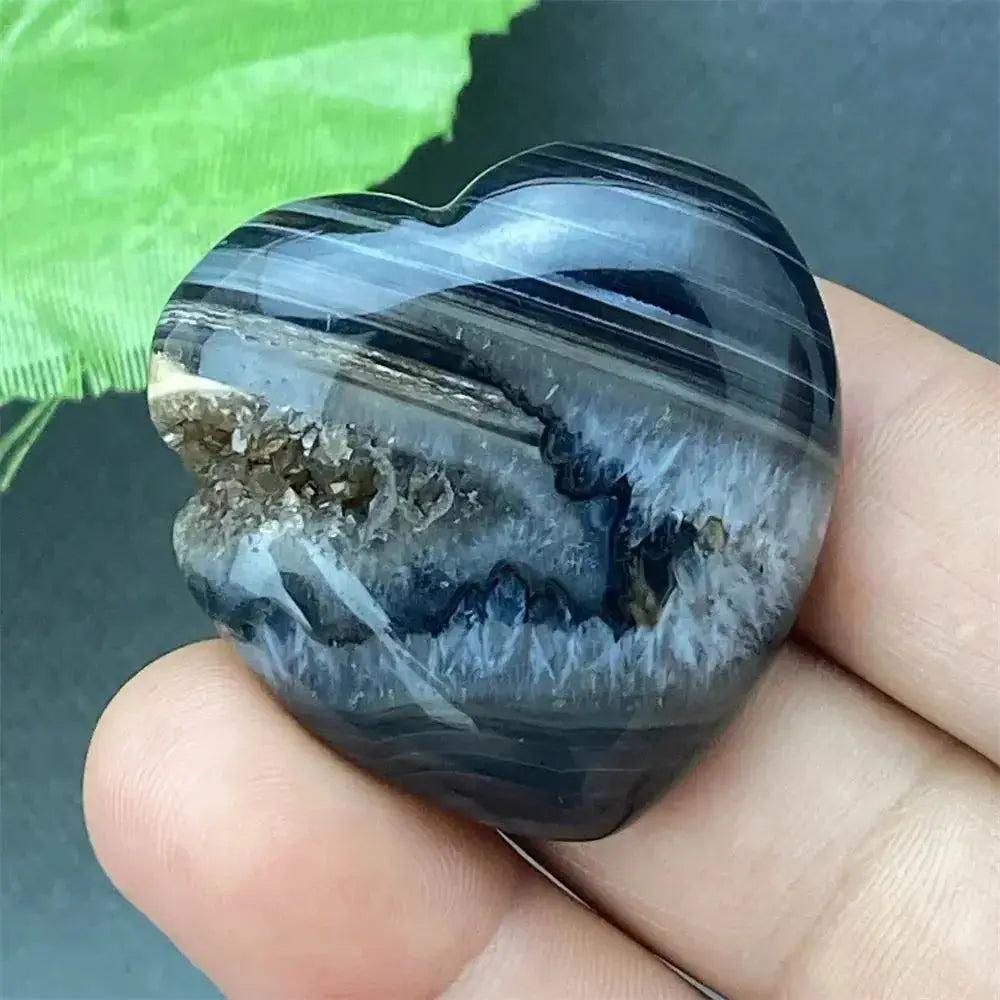 Polished Black Agate geode heart with dark, banded exterior and sparkling druzy crystal cave interior.