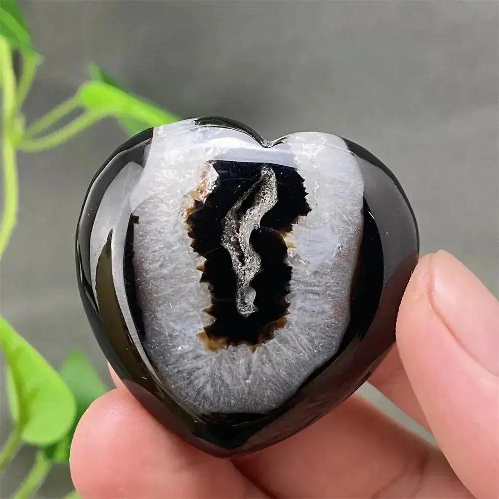 Polished black agate geode heart with a sparkling white and black druzy crystal cave interior.