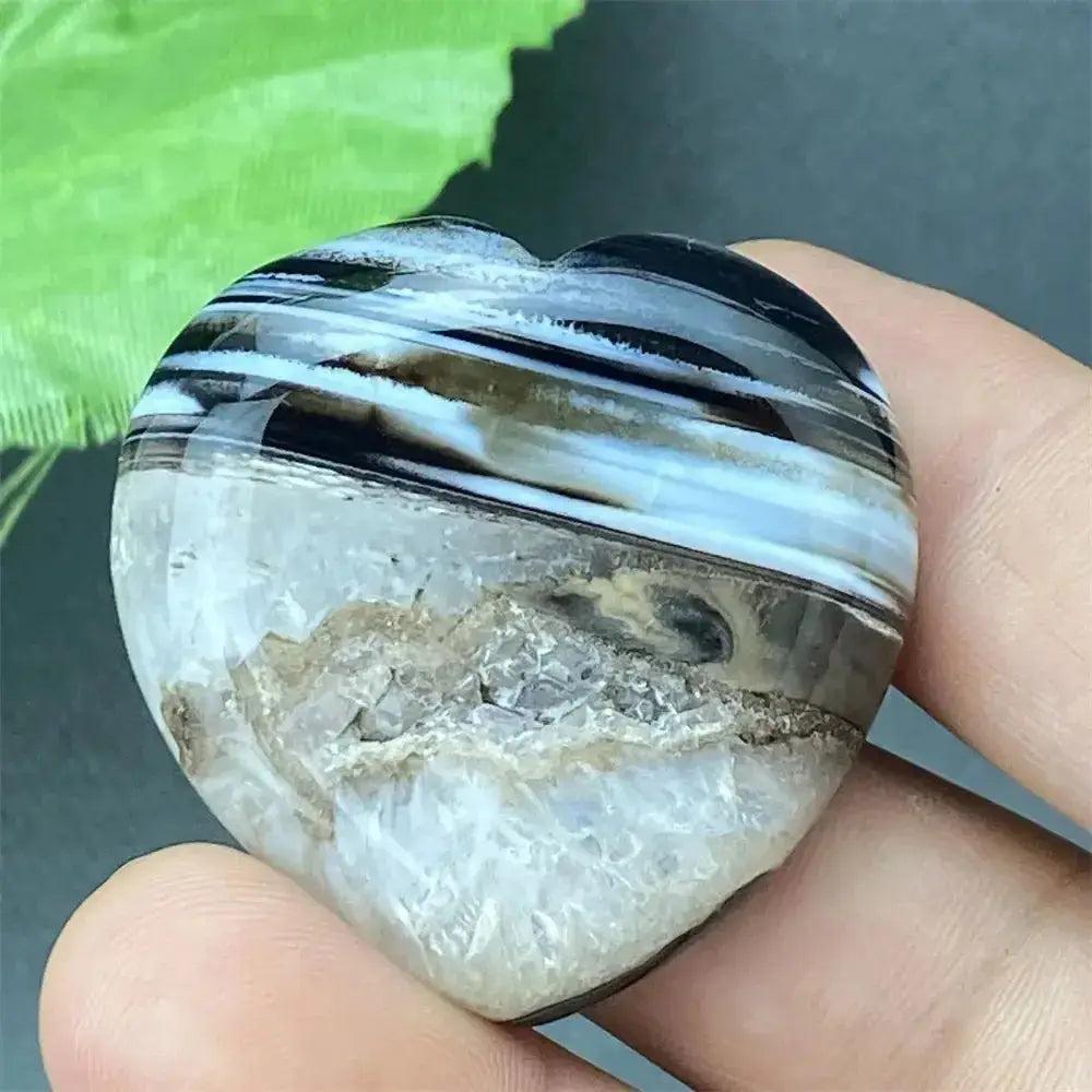 Polished black agate geode heart with natural druzy crystals, offering grounding and protection.