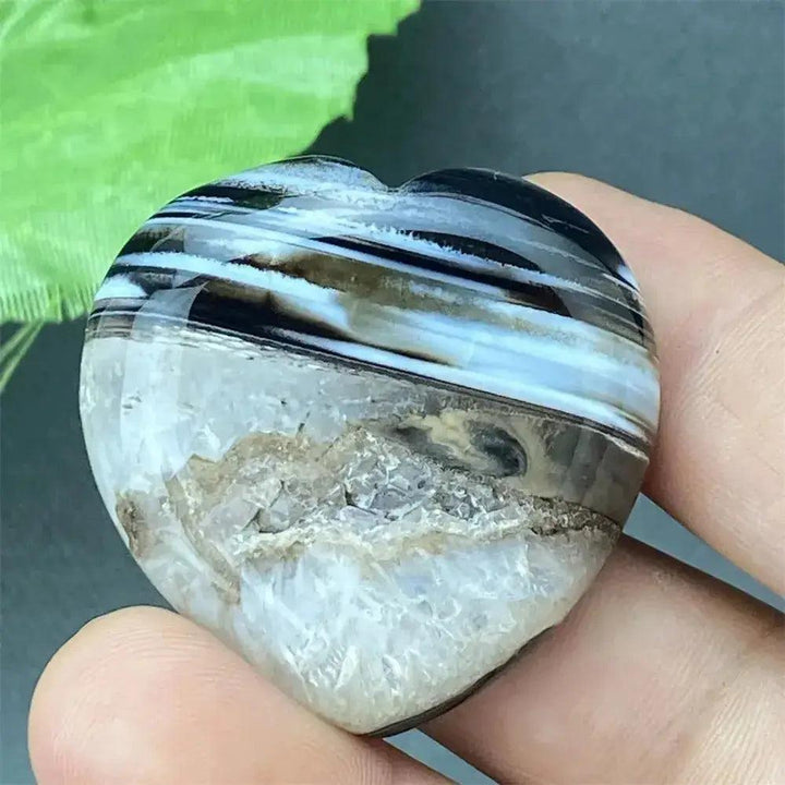 Polished black agate geode heart with natural druzy crystals, offering grounding and protection.