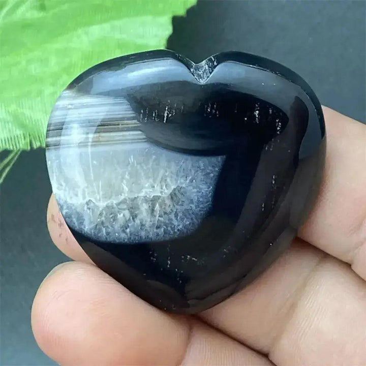 Polished black agate geode heart with a natural druzy crystal cavity, symbolizing grounding and inner strength.