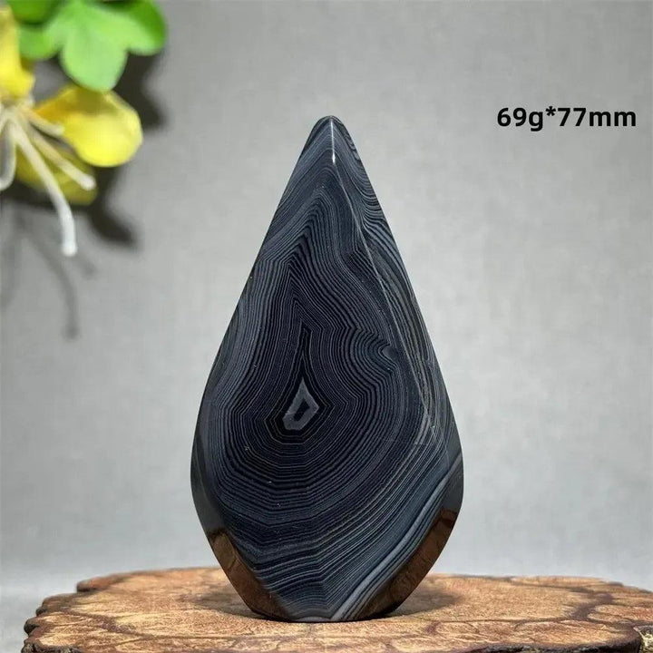 Black Agate Freeform Torch: Polished black agate with white/gray banding in a flame shape, promoting grounding and protection.