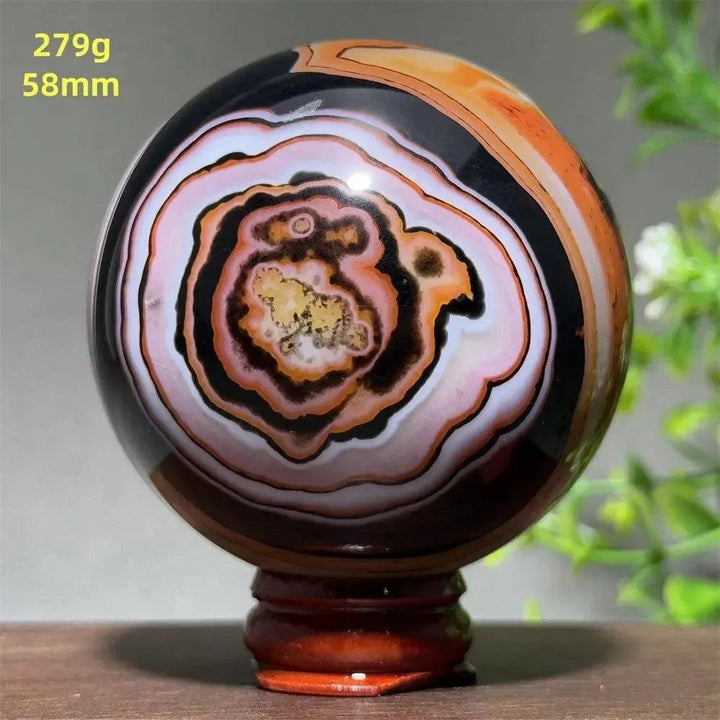 Black Banded Agate Sphere with Stand, showcasing dramatic black, charcoal, white, and orange striations.