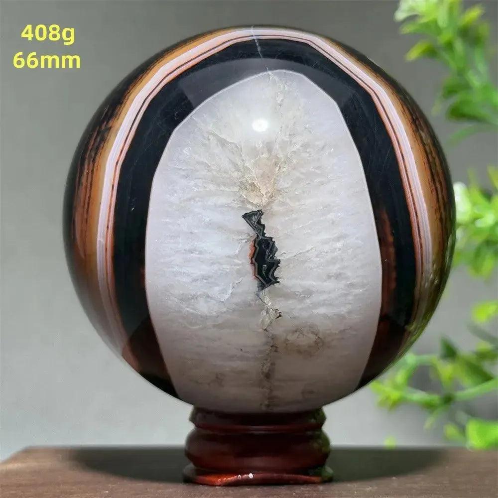 Polished Black Banded Agate Sphere with Stand, showcasing dramatic black, brown, and white striations for grounding energy.