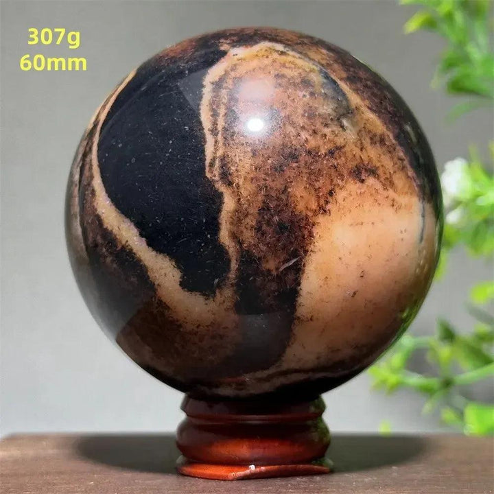 Black Banded Agate Sphere with Stand, showcasing dramatic black and charcoal gray striations for grounding energy.