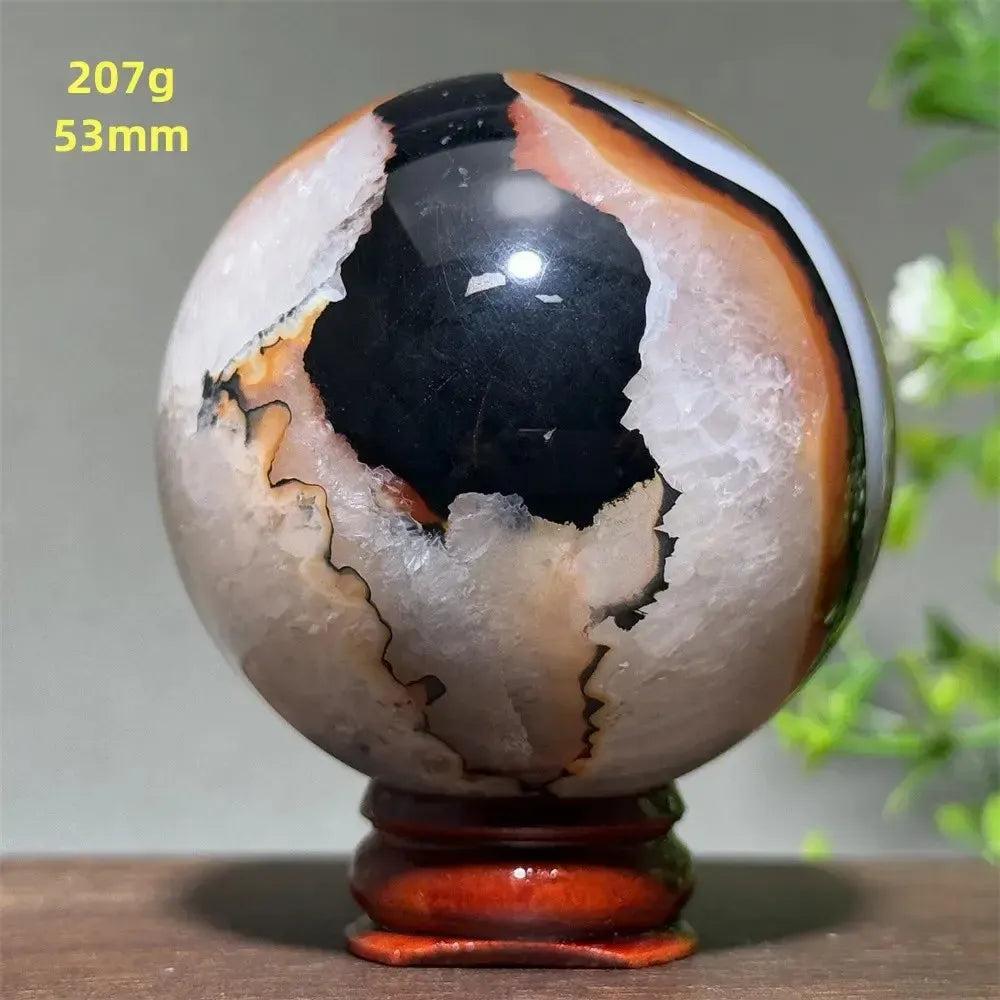 Black Banded Agate Sphere with Stand, showcasing dramatic black, white, and orange striations for protection and grounding.