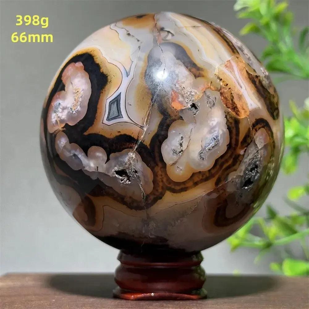 Polished Black Banded Agate Sphere with dramatic black, charcoal, and white striations on a wooden stand.