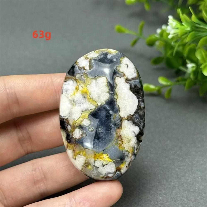63g Black Cherry Blossom Agate palm stone with charcoal, cream, and gold floral patterns for grounding and creativity.