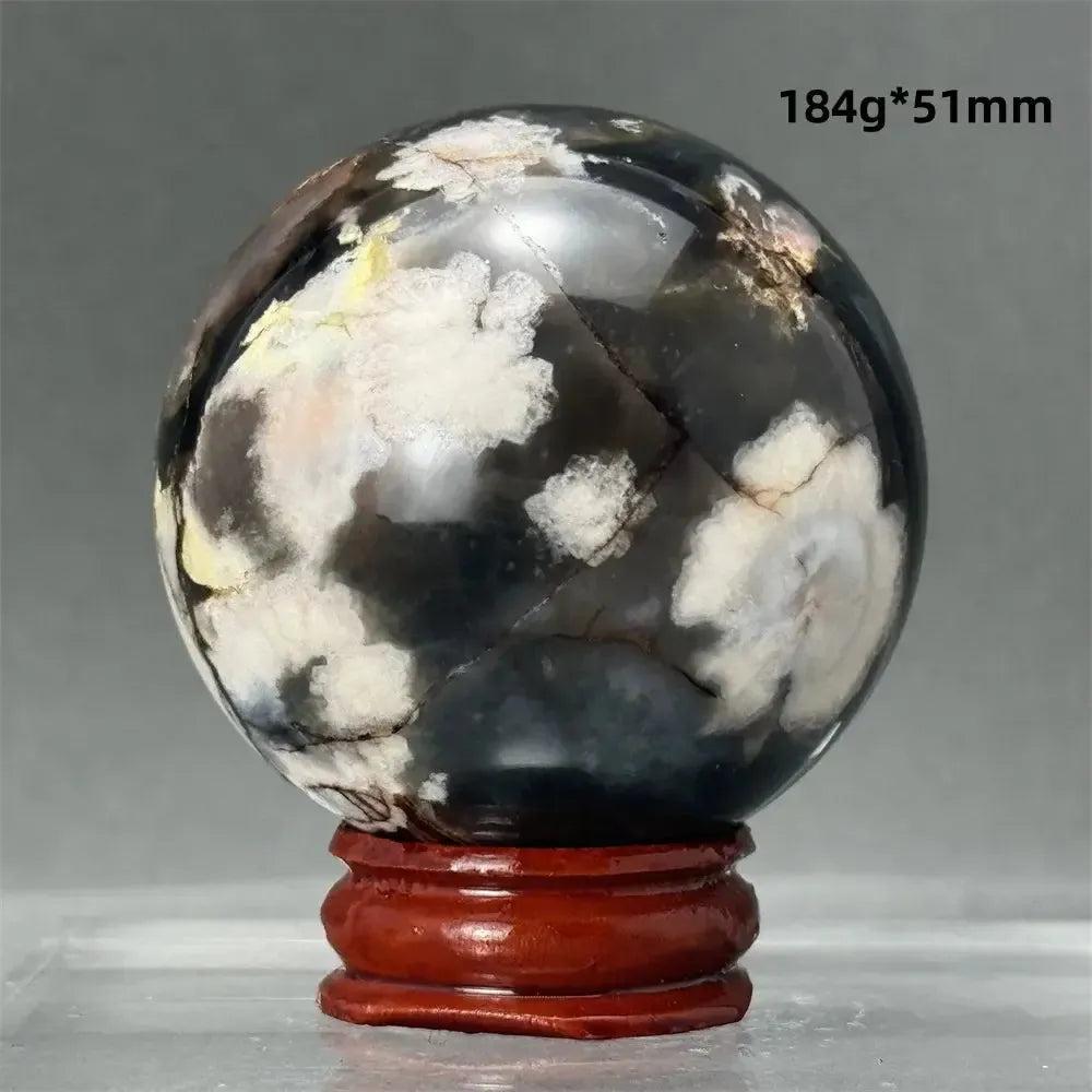 Black Cherry Blossom Agate Sphere, a dramatic dark and light floral patterned chalcedony on a wooden stand.