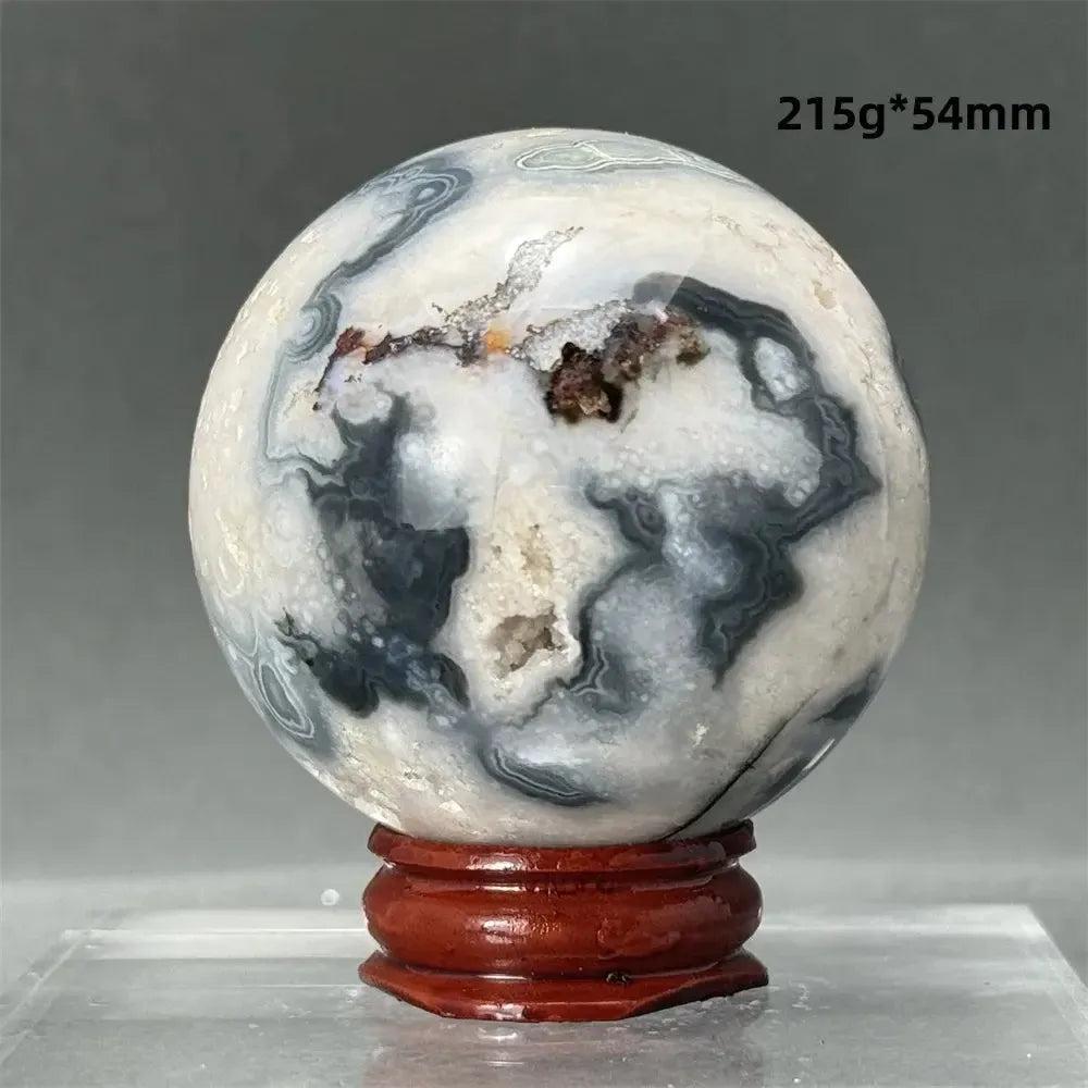 Dramatic Black Cherry Blossom Agate sphere, 215g*54mm, with deep charcoal and creamy white floral patterns on a wooden stand.