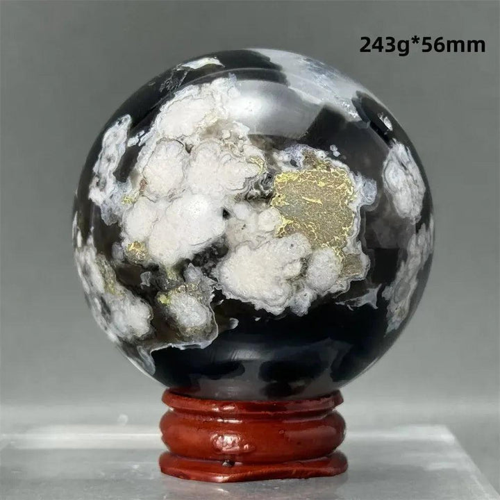 Black Cherry Blossom Agate Sphere, 243g, 56mm. Dramatic dark and light floral patterns with gold accents on a red stand.