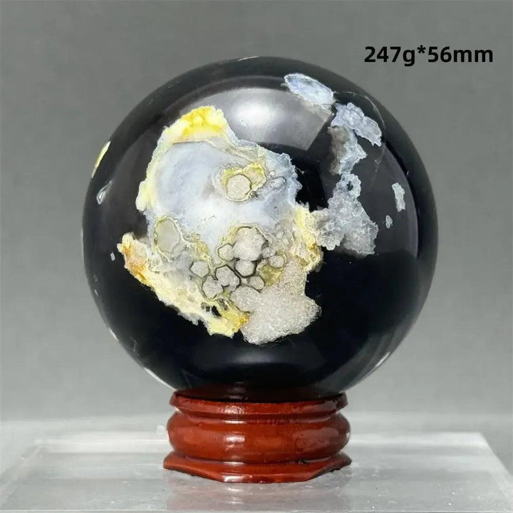 Black Cherry Blossom Agate Sphere, a striking 247g, 56mm polished orb with dramatic dark and light floral banding on a wood stand.