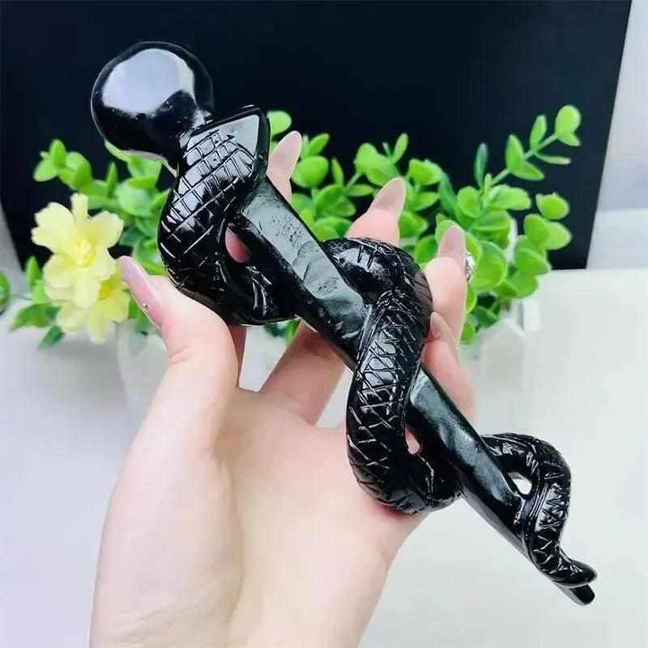 Hand-carved black obsidian snake staff, a polished crystal symbol of healing, transformation, and protective truth.