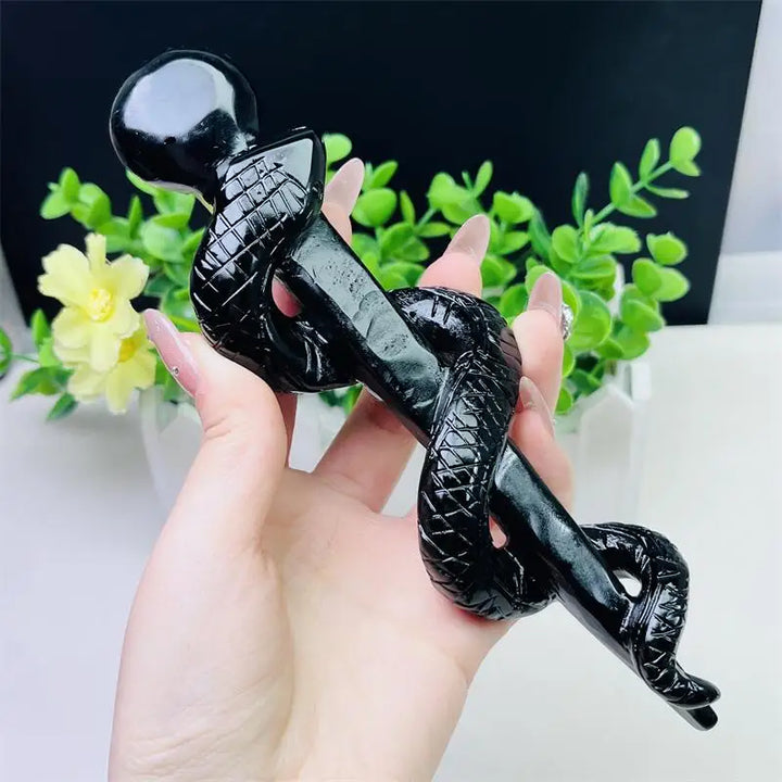 Hand-carved black obsidian snake staff, a polished crystal symbol of healing, transformation, and protective truth.